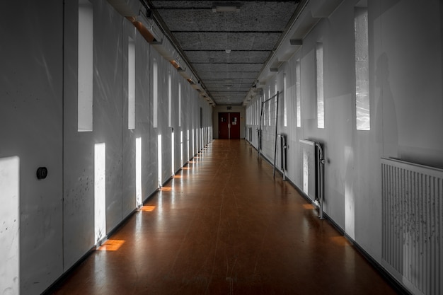 Free photo wide shot of a white hallway with reflections of light from windows