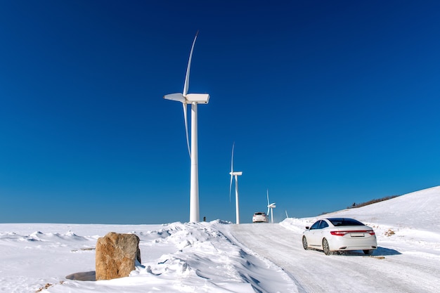 Wind turbine and Car with blue sky in winter landscape