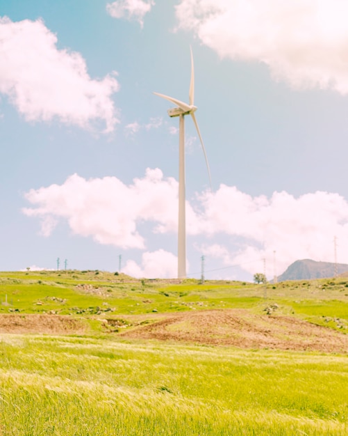 Free photo windmill in green meadow on sunny day