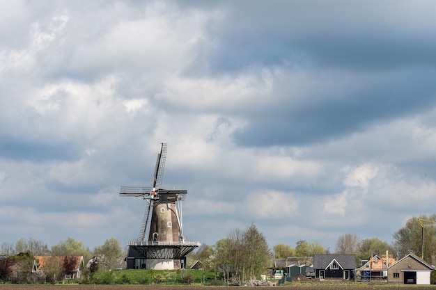 Free photo windmill standing under a cloudy sky at daytime