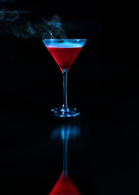 Wineglass with red drink and reflection on surface