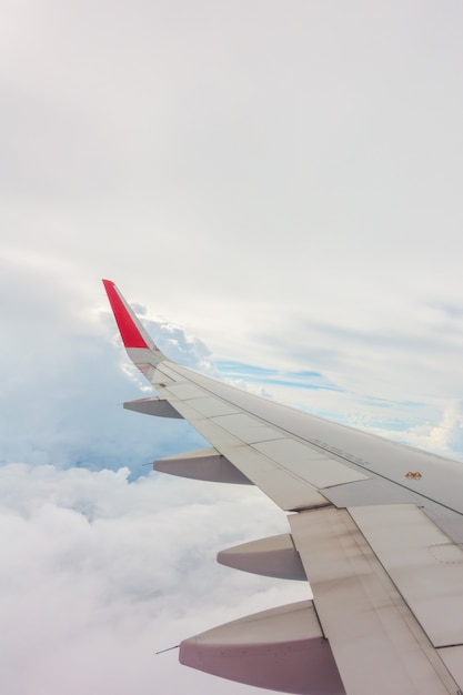 Wing of an airplane flying above the clouds .