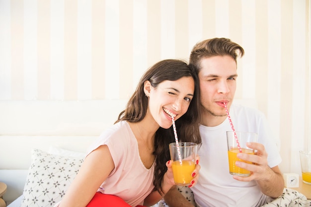 Winking couple posing with juice