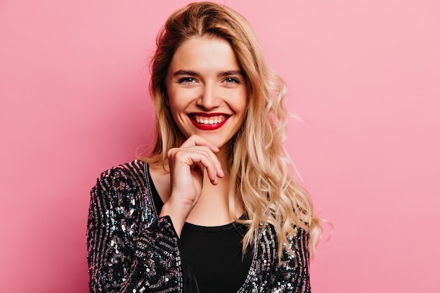 Winsome caucasian woman with blonde hair laughing . Indoor portrait of stunning caucasian girl with red lips.