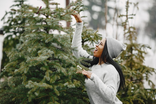 Free photo winter concept. woman in a gray sweater. saleswoman of christmas tree.