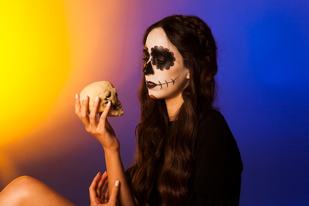 Free Photo witch looking at a skull