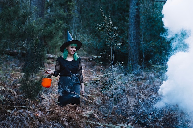 Witch woman at smoke in woods