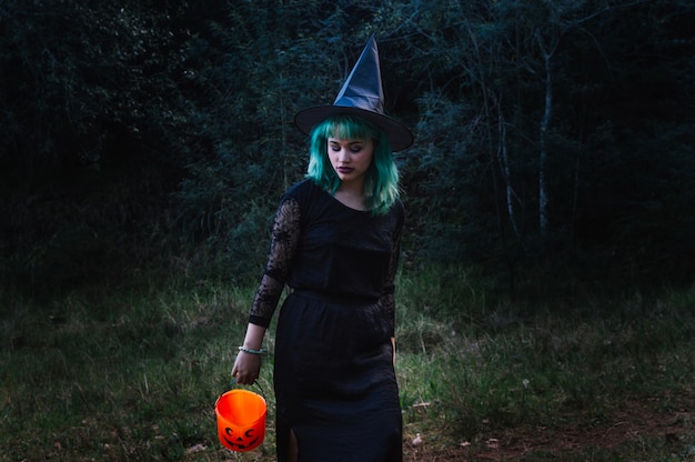 Free Photo witch woman with pumpkin in forest