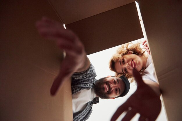 With elongated hands. Happy couple together in their new house. Conception of moving