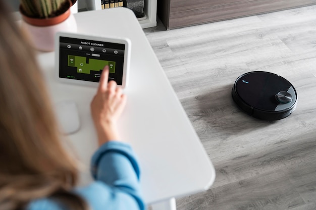 Free Photo woman activating robot cleaner