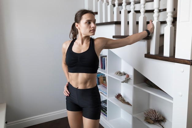 Free photo woman in activewear posing next to stairs