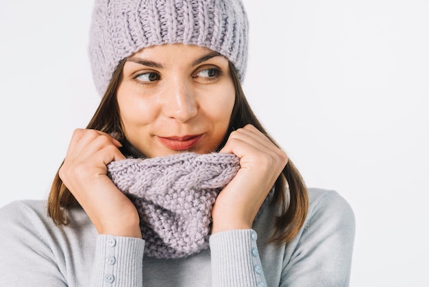 Woman adjusting scarf and looking away