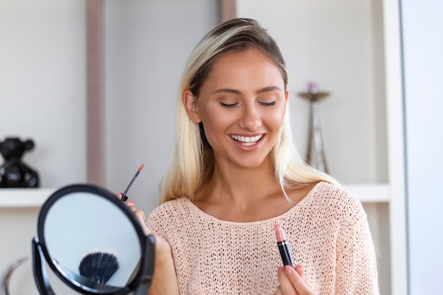 Free photo woman applying black mascara on eyelashes with makeup brush beauty makeup portrait of beautiful young woman applying black mascara on lashes holding brush in hand