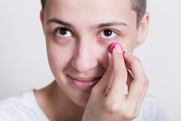 Woman applying cream for dark circles