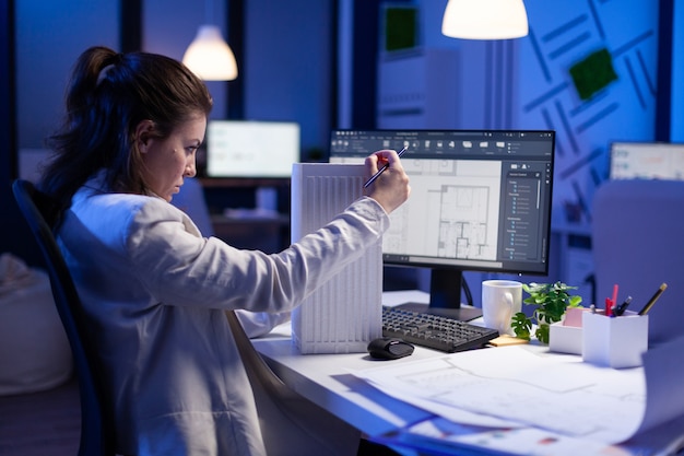 Free photo woman architect analysing and matching blueprints for new building project