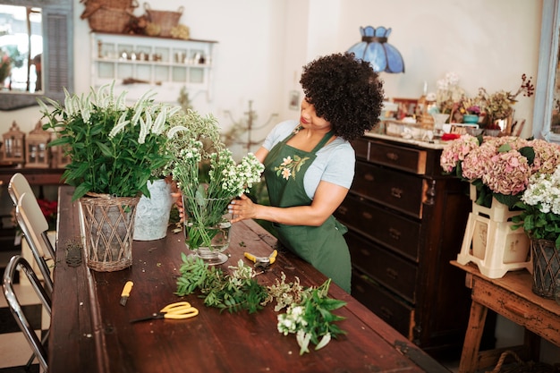 Woman arranging flowers on wooden table