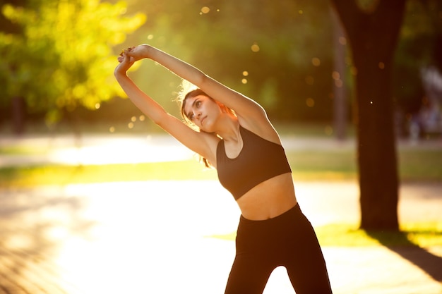 Woman athlete training in the city street, summer day.