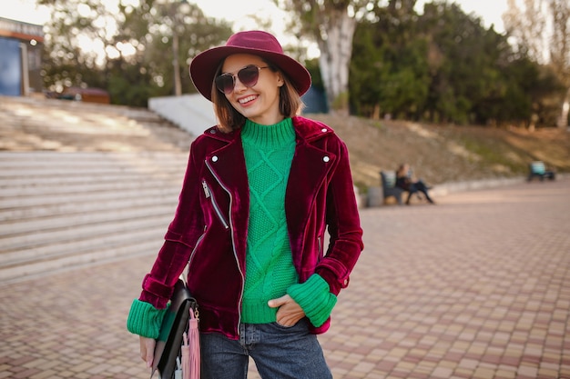 Free photo woman in autumn style trendy outfit walking in street wearing purple velvet jacket, sunglasses and hat