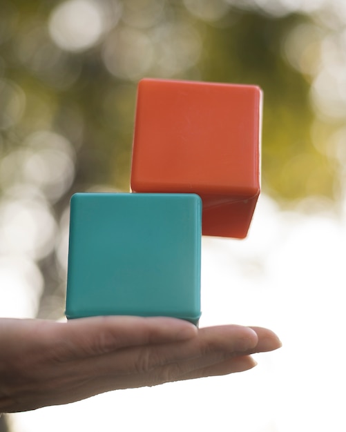 Free Photo woman balancing colored plastic cubes