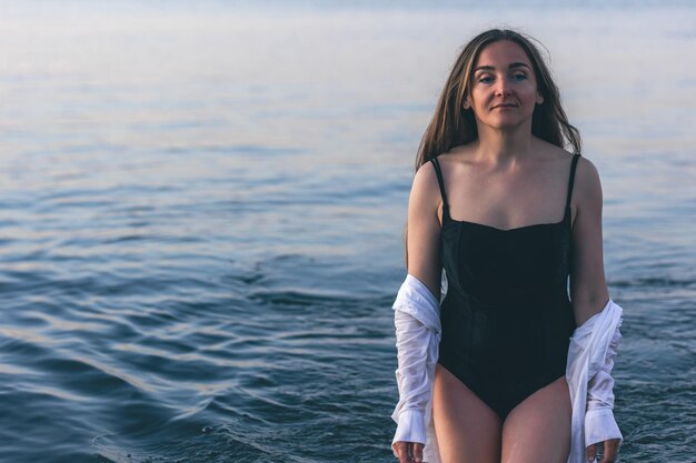 A woman in a bathing suit and a white shirt in the sea