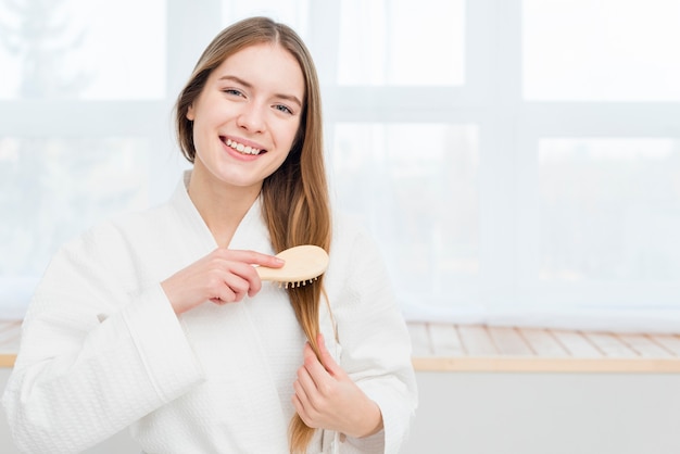 Woman in bathrobe brushing her hair