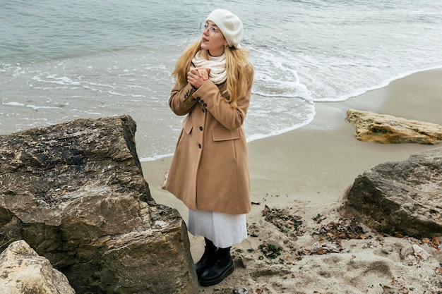 Free photo woman at the beach during winter