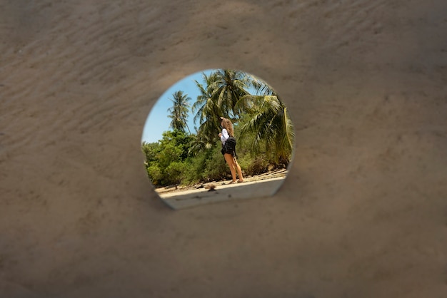 Woman at the beach in summer posing with round mirror