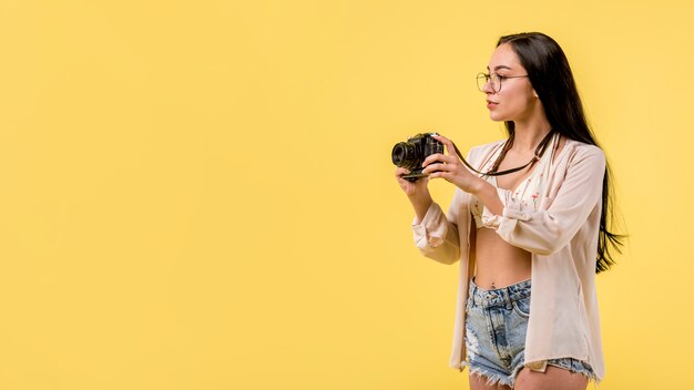 Woman in beachwear holding photo camera and taking picture