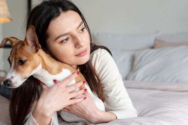 Woman in bed posing with her dog