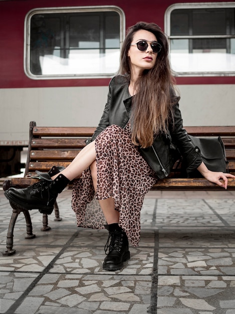 Free photo woman on bench at train station