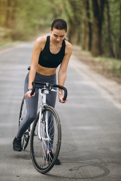 Woman biking in forest