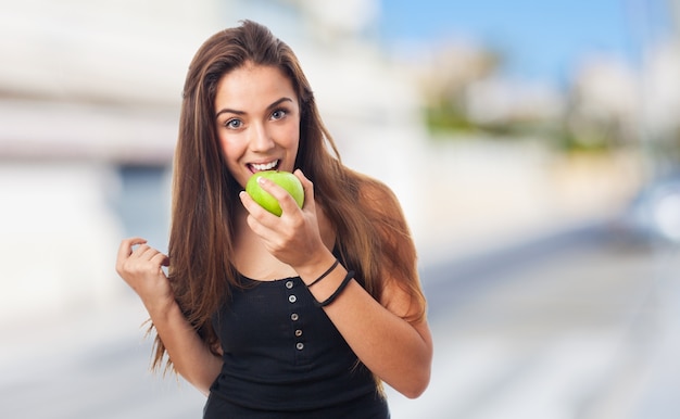 Woman biting a green apple