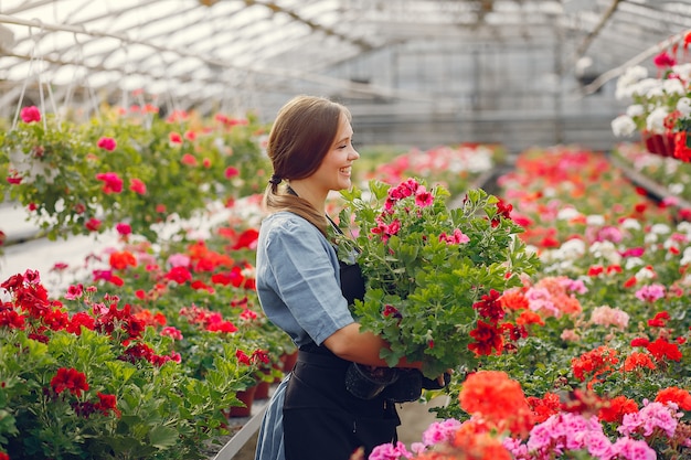 Woman in a black apron working in a greenhouse