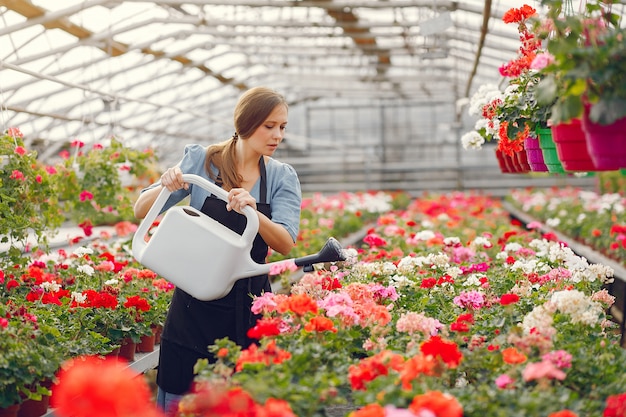 Woman in a black apron working in a greenhouse