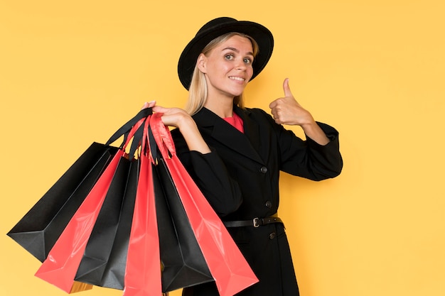 Woman on black friday sale thumbs up gesture with bags