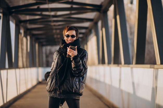 Free Photo woman in black jacket walking through the bridge