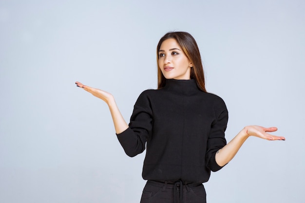 woman in black shirt pointing at something on the left. 