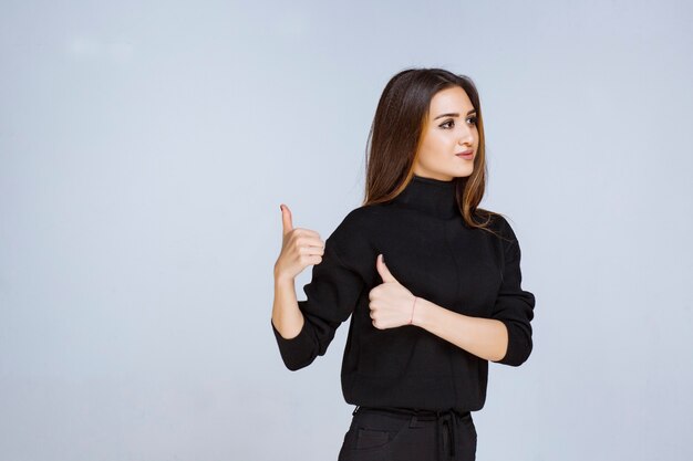 woman in black shirt showing positive hand sign. 