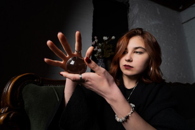 Woman in black suit holding crystal ball in her hands