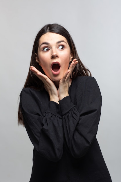 Woman in black sweater demonstrates suprice