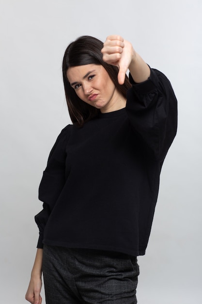 Free photo woman in black sweater shows thubs down