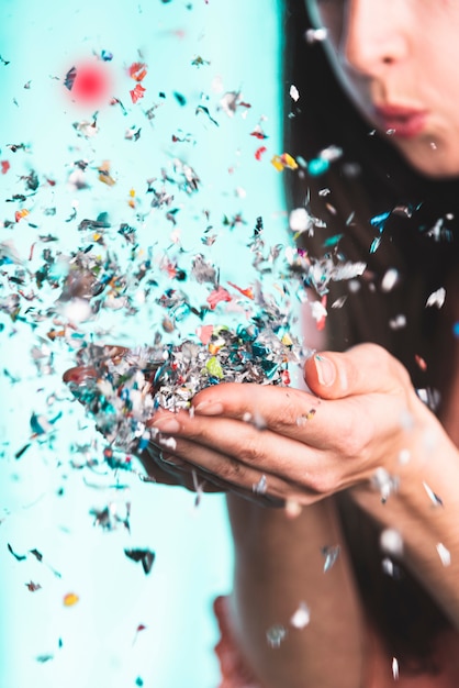 Free Photo woman blowing confetti from her hands