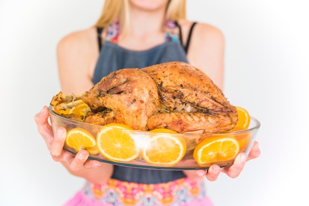 Woman in blue cover slut with baked turkey in glassware