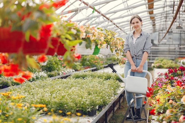 Woman in a blue shirt pours flowerpots