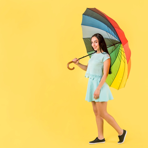 Free photo woman in blue with rainbow umbrella