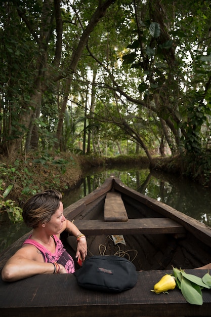 Free Photo woman in a boat in a tropical river