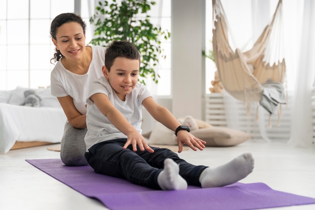 Woman and boy on yoga mat full shot