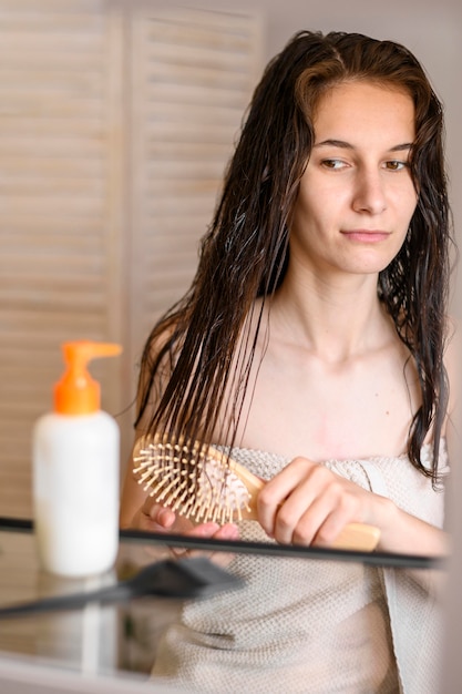 Free photo woman brushing hair after washing it