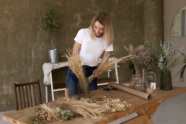 Free photo woman building her own dried flowers arrangement