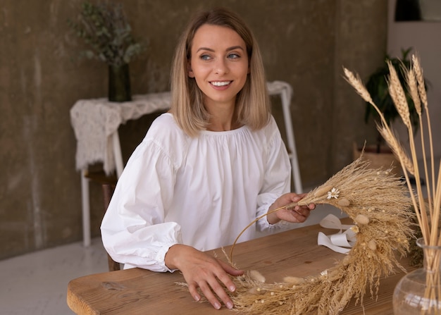 Woman building her own dried flowers arrangement